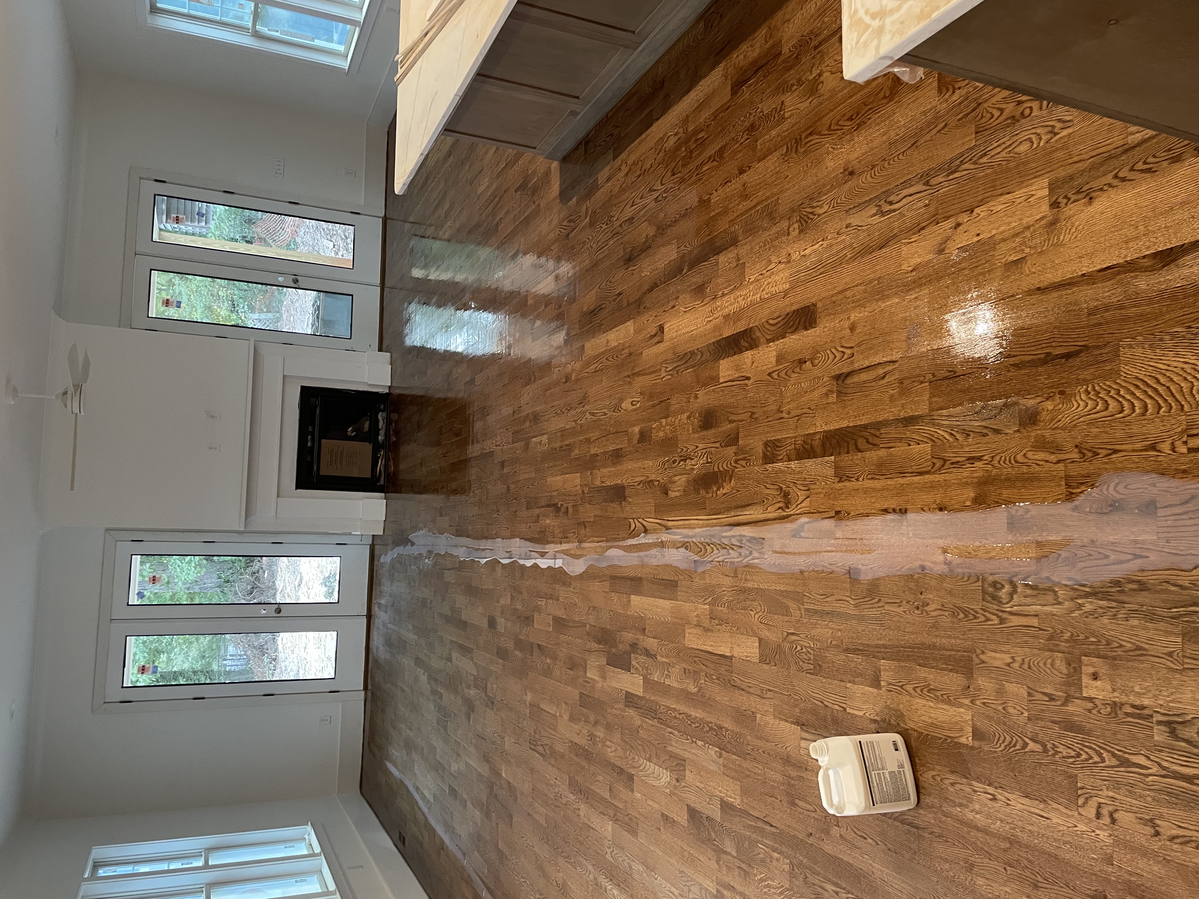 Water-based finish being applied to hardwood flooring in a residential living room