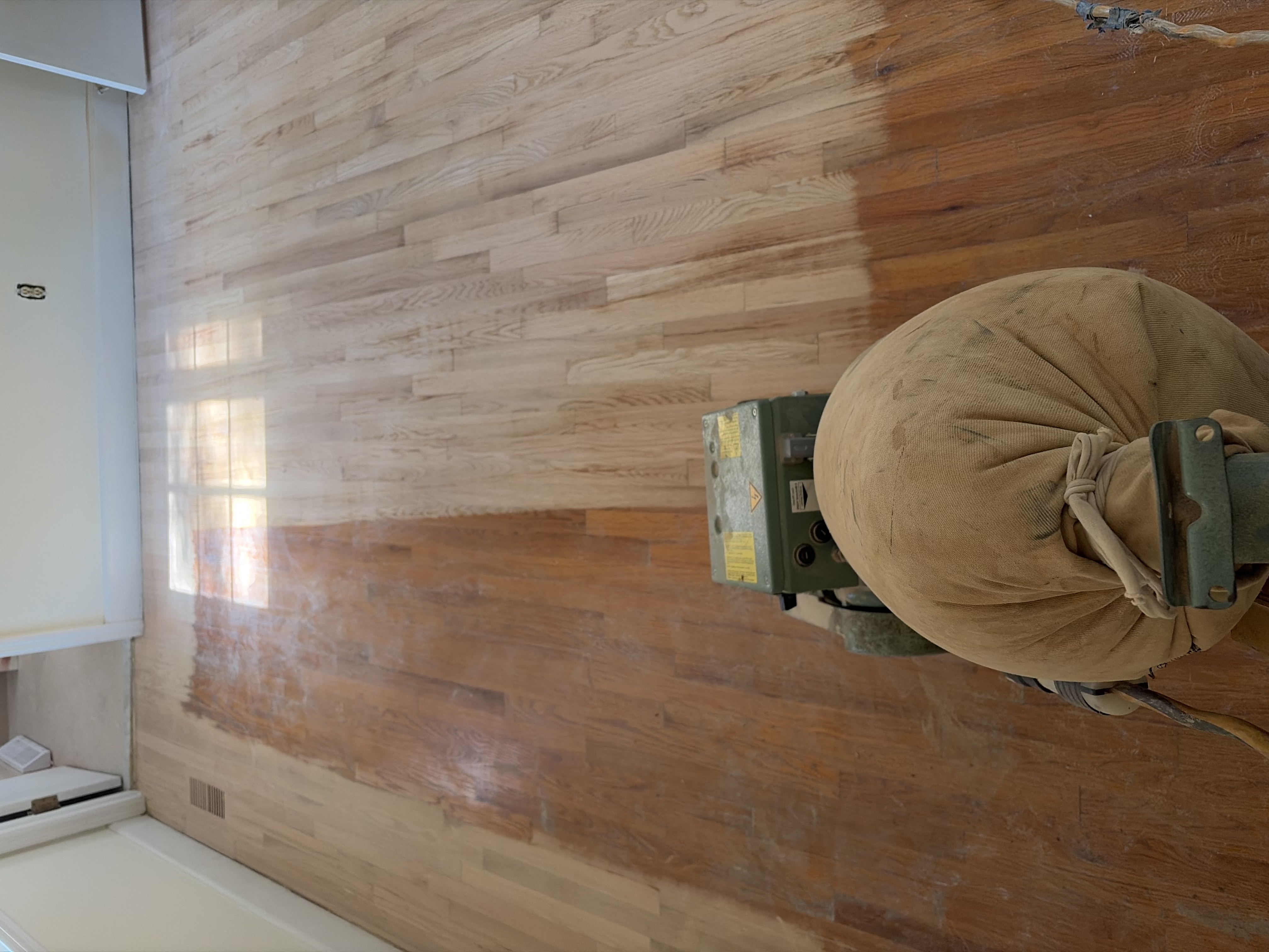 Oak hardwood floors being sanded during an older-home remodel