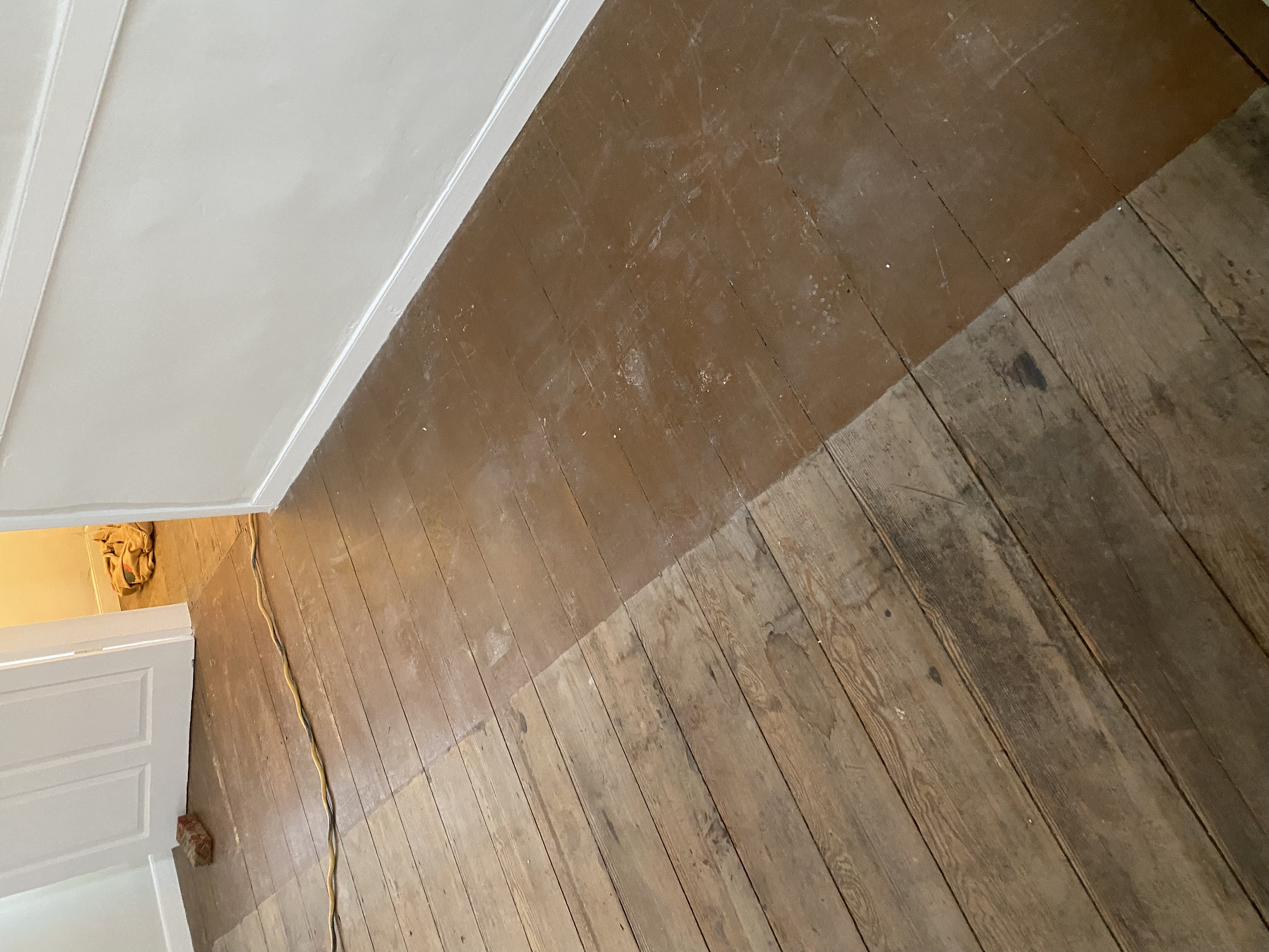 Worn original hardwood flooring with visible surface wear before restoration