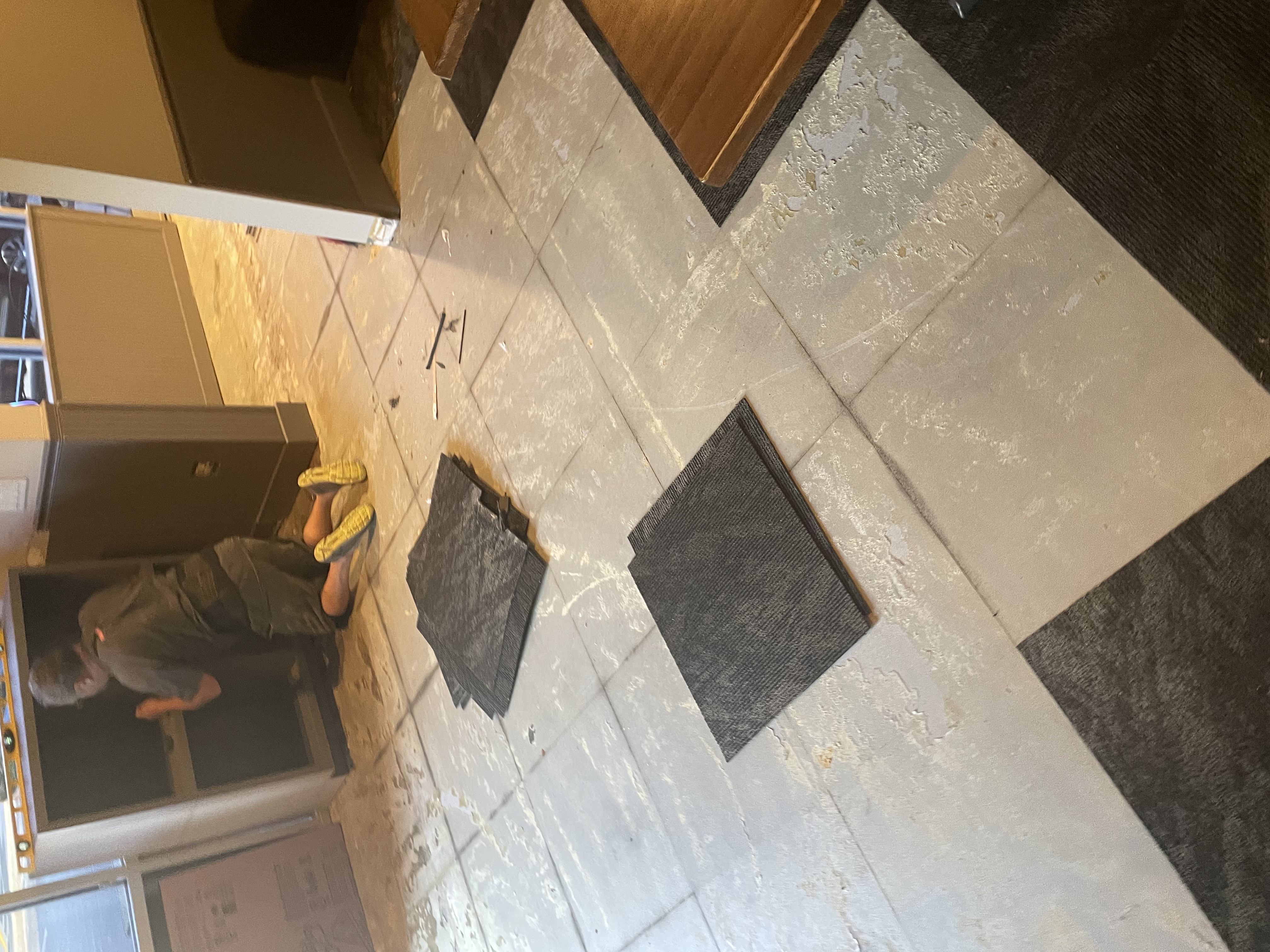 Existing square tile flooring being removed from a commercial space