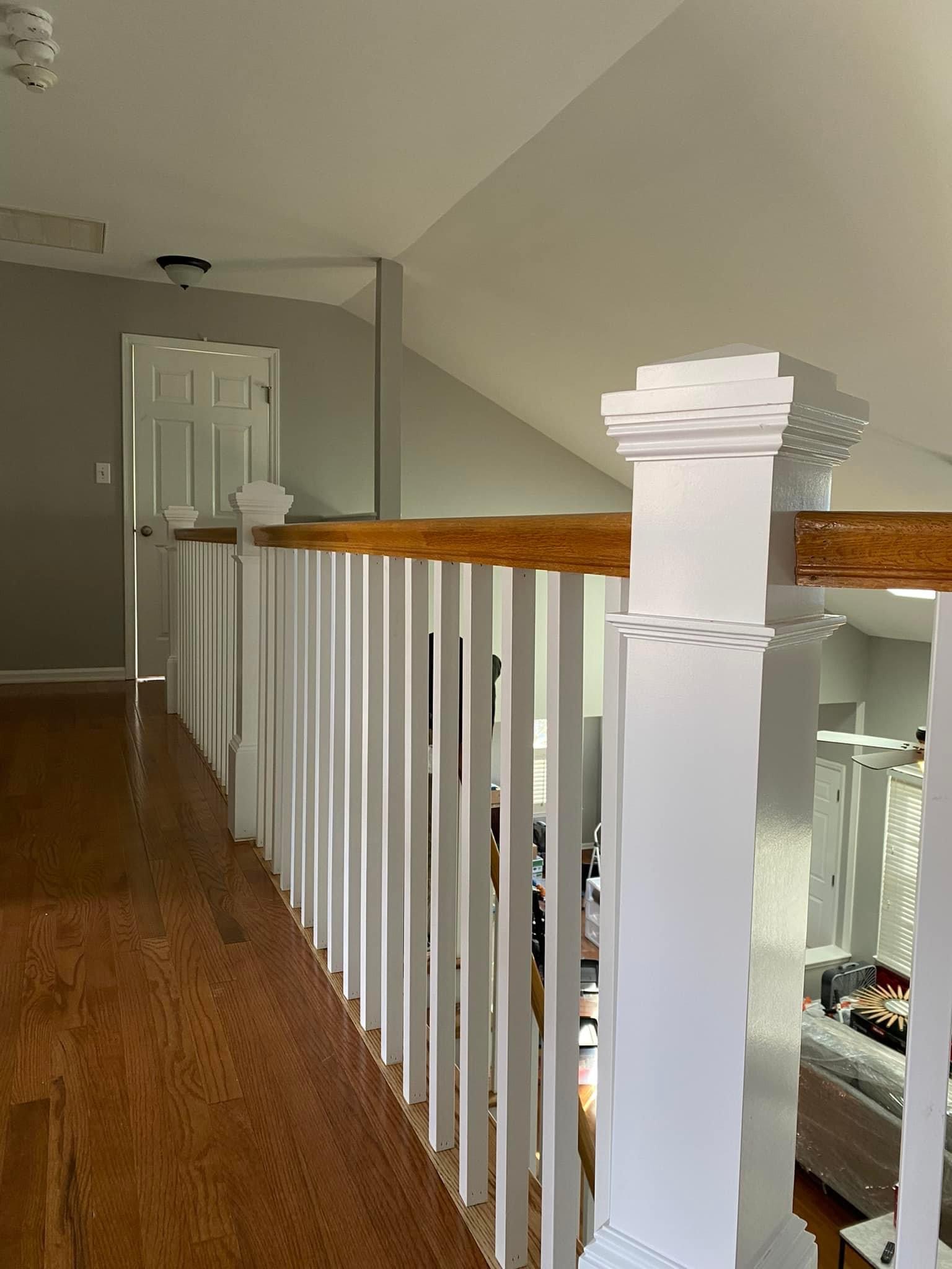 Completed prefinished hardwood in the upstairs hallway with new pickets and banisters